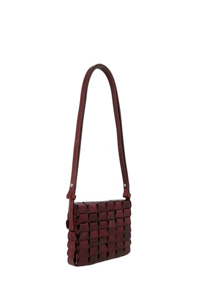 Borsa a tracolla in pelle intrecciata rossa, con una lunga tracolla, caratterizzata da una forma rettangolare e una superficie liscia. Notevole motivo a griglia sulla superficie.