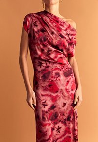 Czerwona i różowa sukienka na jedno ramię z drapowaną konstrukcją, gładkim materiałem w wzór tie-dye oraz dopasowanym krojem.