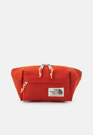 Kompaktowa pomarańczowa nerka z dwoma suwakami i przednią kieszenią, oznaczona napisem "The North Face Fine Alpine Equipment".