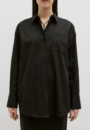 Zwarte langomlje shirt met knopen, gemaakt van gladde stof, met een borstzak, puntige kraag en een licht gebogen zoom.