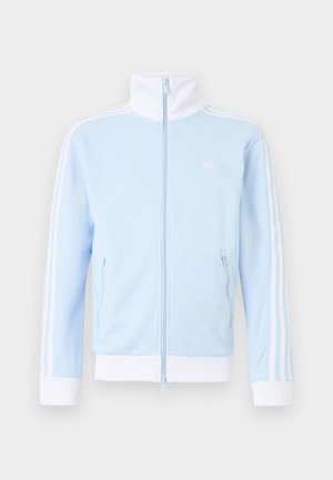 Hellblaues Trainingsjacke mit Reißverschluss, weißem hohem Kragen, Bündchen, Saum und drei weißen Streifen entlang der Ärmel, ausgestattet mit zwei Reißverschlusstaschen.