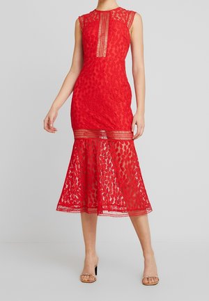 Hihaton punainen pitsimidi-mekko kukkakuviolla, läpikuultavilla paneeleilla rinnassa ja helmassa, pidetty avoimilla kärkikoroilla.