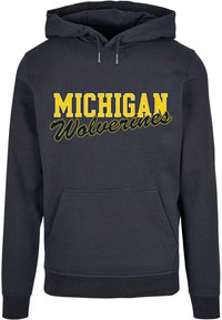 Sweat à capuche marine avec "MICHIGAN Wolverines" en texte jaune et blanc, doté d'une poche kangourou et d'une capuche à cordon de serrage. Tissu doux, coupe décontractée.