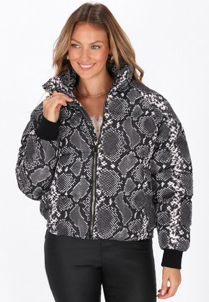 Giubbotto imbottito con un motivo di stampa a serpente in bianco e nero, dotato di un colletto alto, chiusura con zip e polsini a costine. Materiale testurizzato.