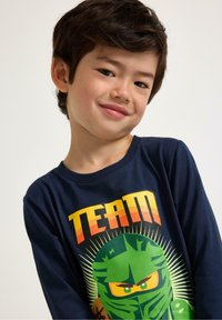 T-shirt a maniche lunghe blu navy in cotone, con una grafica colorata di un ninja e il testo "TEAM" sopra.