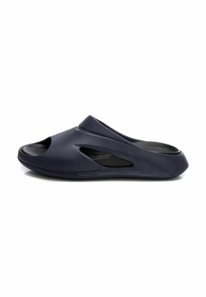 Zapato de casa de color navy con diseño de punta abierta, superficie texturizada y acentos recortados para ventilación. Material ligero y flexible.