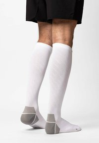 Calze bianche fino al ginocchio con un motivo testurizzato, con dettagli grigi sul tallone e sulla punta. Realizzate in un materiale leggero e traspirante.