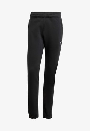 Pantalones de chándal negros hechos de una tela suave, con una cinturilla elástica, piernas ajustadas y un logo blanco de Adidas en el muslo izquierdo.