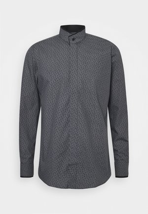 Camisa de manga larga en gris oscuro con pequeño patrón de texto blanco, cuello alto con botón y dobladillo curvo sobre fondo liso.
