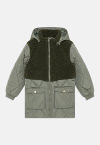 Vadderad grön jacka med en mjuk, mörkgrön fuskpäls på bröstpanelen, huva, två framfickor och knappar i guldton.