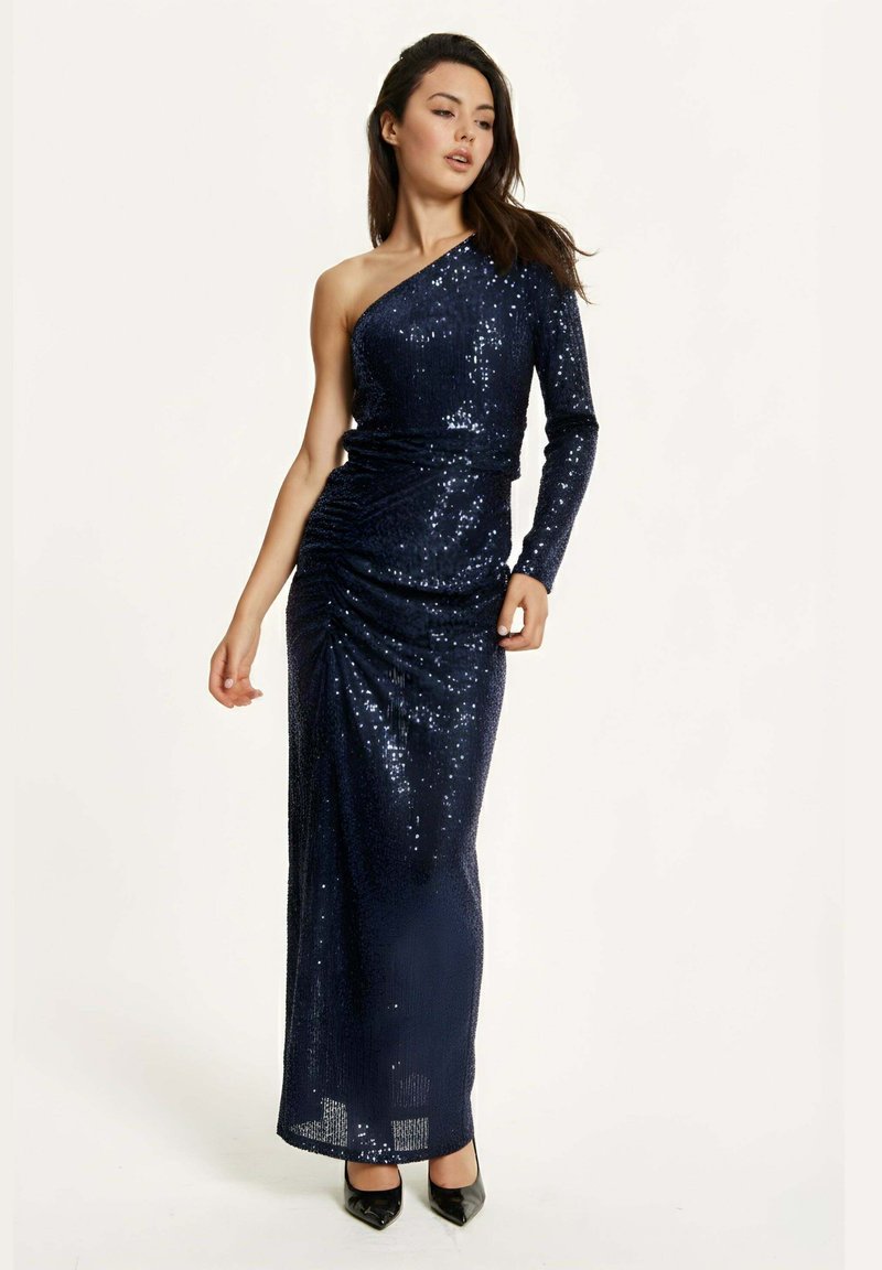 Navy sequin dress with one shoulder design, ruched detailing, and a floor-length silhouette. Glossy texture and fitted shape accentuate the figure.