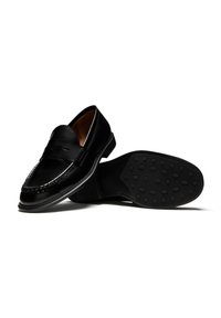 Schwarze Lederloafers mit abgerundetem Zeh, dekorativen Nähten, einer Münzöffnung und einer strukturierten Gummisohle mit ovalen Vertiefungen.