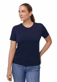 Marineblå kortærmet t-shirt i blødt stof med rund halsudskæring, parret med lyseblå denim jeans. Enkel, klassisk design.