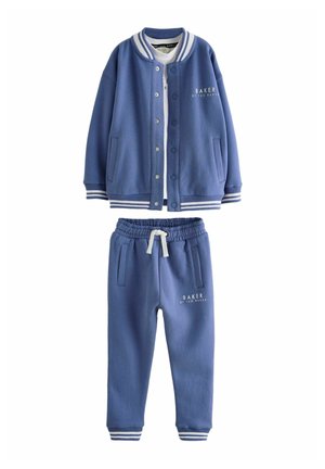 Conjunto de sudadera y pantalones de chándal azules; cuenta con un diseño deportivo con rayas blancas, botones a presión y logotipo impreso en ambas piezas.