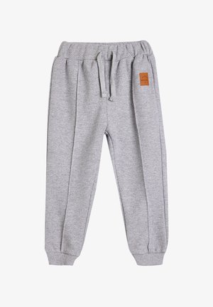 Pantalones de chándal grises de punto con cintura elástica, cordón, puños acanalados y un pequeño detalle de parche de cuero marrón en el frente.