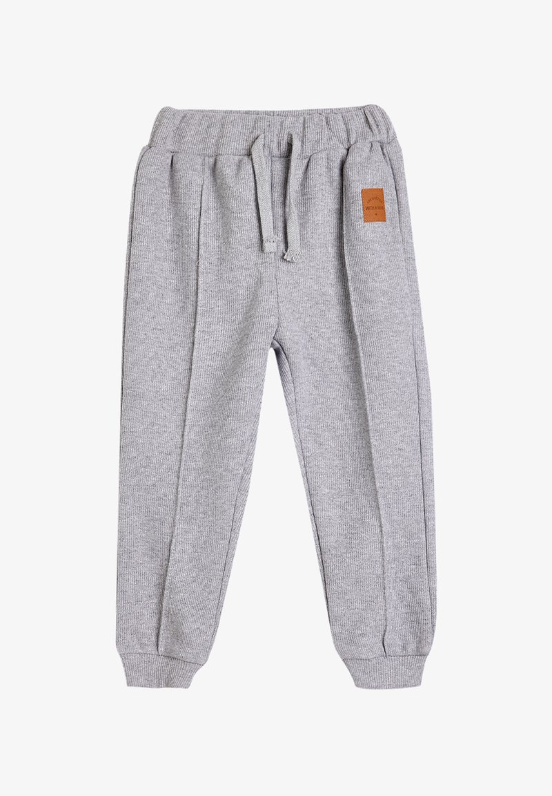 Gray knit sweatpants with an elastic waist, drawstring, ribbed cuffs, and a small brown leather patch detail on the front.