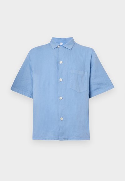 Lys blå kortermet skjorte laget av lin med knapper foran, spiss krage og en enkelt brystlomme. Glatt tekstur.