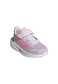 Zapatilla deportiva de color púrpura claro con parte superior de malla, correa ajustable, suela blanca y tres rayas rosas en el lado.