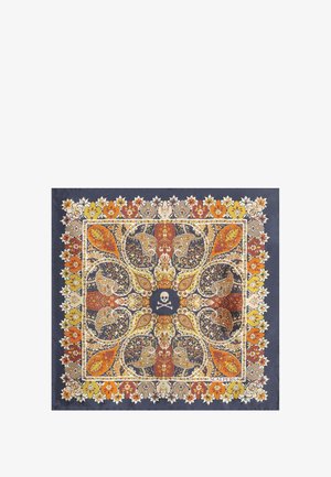 Pañuelo de seda con un patrón de paisley en naranja, amarillo y azul oscuro, con un motivo central de calavera, enmarcado por acentos florales.