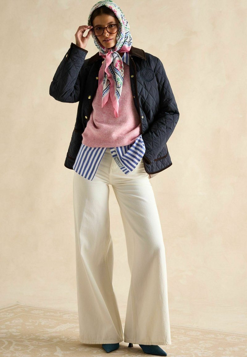 Navy'owa kurtka pikowana, jasnoróżowy sweter, niebieska i biała bluzka w paski pod spodem, szerokie białe spodnie, szal w kwiatowy wzór, turkusowe szpilki.