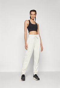 New Balance WARMING PERFORMANCE JOGGER - Jogginghose - offwhite