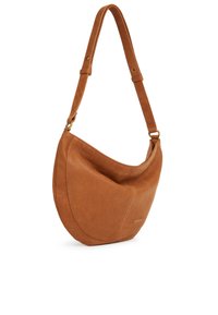 Tan leather shoulder bag with a curved design, single adjustable strap, and subtle gold hardware detail. Smooth texture with minimal stitching.