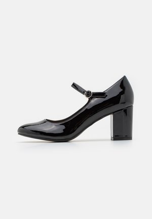 Zapato tipo Mary Jane de charol negro con punta redonda, correa al tobillo y tacón cuadrado. Textura suave y diseño elegante.