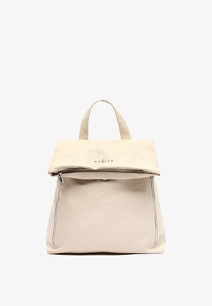 Sac à dos en cuir beige avec rabat repliable, fermeture à glissière, deux zips latéraux et cinq clous décoratifs à l'avant.