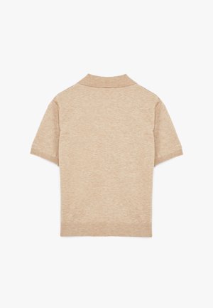 Polo a maniche corte beige con colletto e orlo a costine. Realizzato in un tessuto morbido e testurizzato, con un colore uniforme. Nessun motivo o dettaglio decorativo.