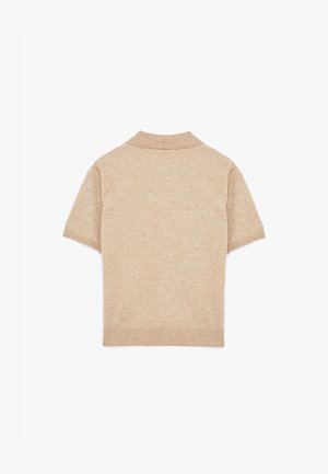 Beige kortærmet polo skjorte med ribbet krave og kant. Lavet af et blødt, struktureret stof, der viser en ensartet farve. Ingen mønstre eller accenter.