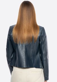 Navylederjacke mit taillierter Passform, strukturierten Schultern und cropped Saum. Die Textur ist glatt mit dezentem Glanz.