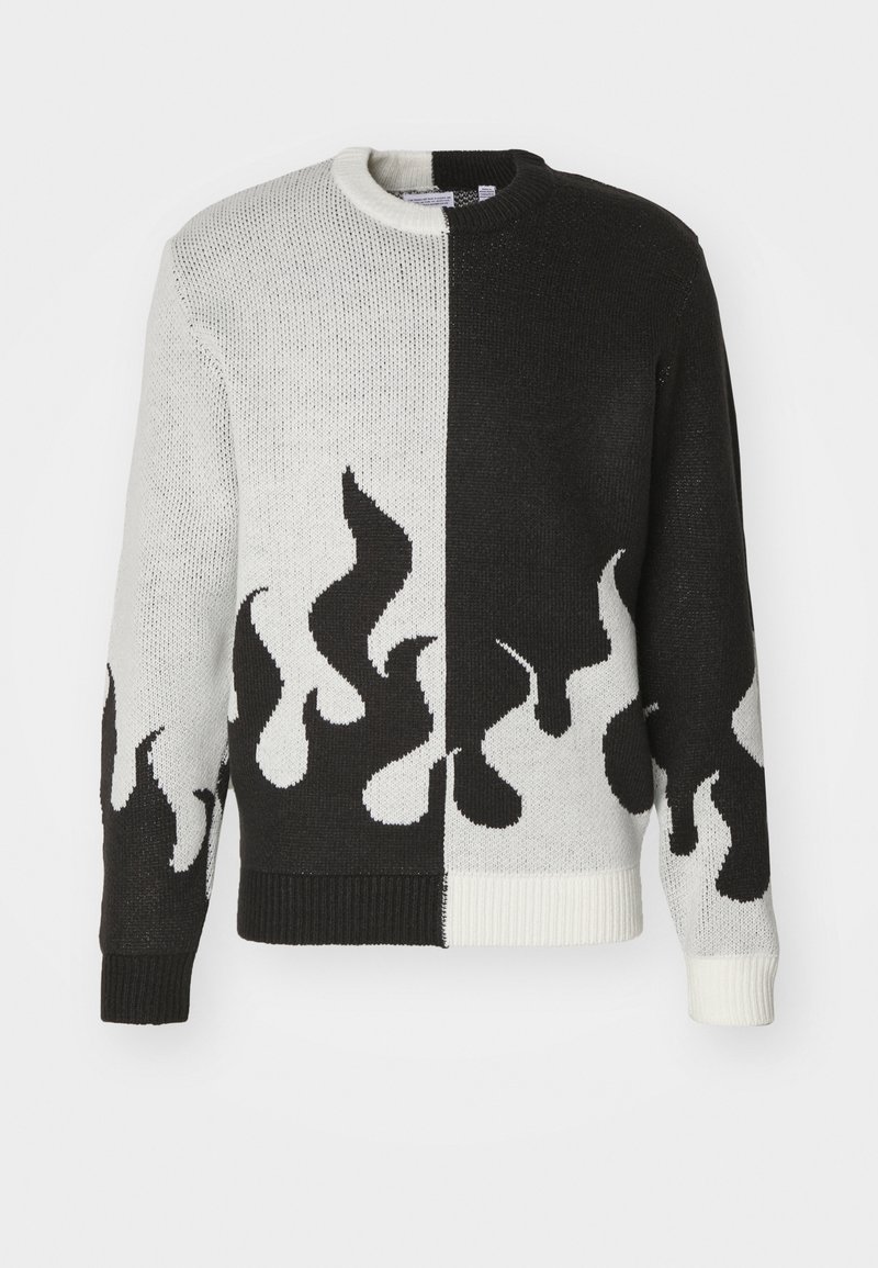 Gebreide trui met een gesplitst ontwerp; de ene helft zwart, de andere wit. Heeft vlammenpatronen in zwart en wit langs de zoom en mouwen.