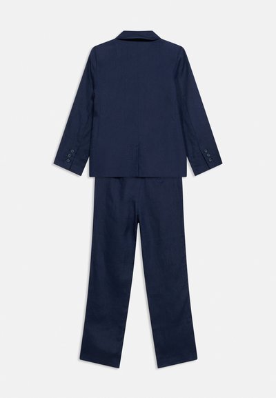 Μπλε κοστούμι ναυτικού στυλ που αποτελείται από σακάκι με μανσέτες με κουμπιά και αντίστοιχο παντελόνι με ίσια γραμμή, εμφανιζόμενο από πίσω σε λευκό φόντο.