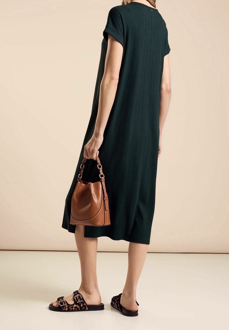 Vihreä raidallinen midimekko, jossa on kääntösateet, yhdistettynä ruskeaan käsilaukkuun ja leopardikuvioisiin liuku sandaaleihin. Sileä tekstuuri, rento malli.