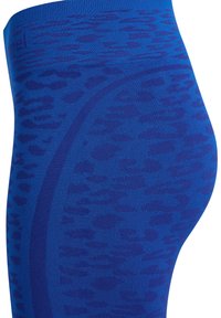 Bezszwowe niebieskie legginsy z wysokim stanem, z ciemnoniebieskim wzorem w cętki lamparta i gładkimi liniami konturów.