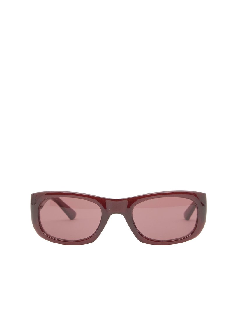 Occhiali da sole rettangolari con montatura spessa e lucida di colore rosso scuro e lenti tono su tono, su sfondo bianco.