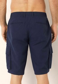Pantaloni scurți cargo de marină, cu o talie elastică confortabilă, două buzunare laterale și două buzunare la spate, fabricați dintr-un material ușor.