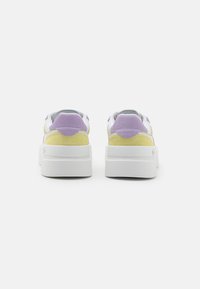 Wielokolorowe sneakersy z białą podeszwą, żółtymi i lawendowymi akcentami z zamszu oraz górą z gładkiej skóry. Miękka tekstura, casualowy design.