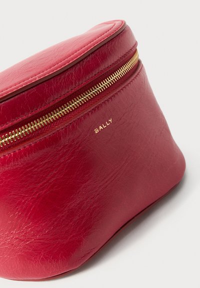 Κόκκινο δερμάτινο πορτοφολάκι Bally με χρυστό φερμουάρ και μικρό ανάγλυφο με το όνομα της μάρκας μπροστά.