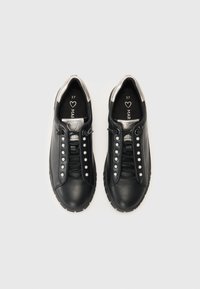 Sneaker nere in pelle con accenti argentati, punta rotonda, suola piatta in gomma e borchie decorative lungo i lacci. Taglia 37 stampata all'interno.