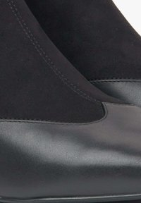 Czarne botki za kostkę z połączenia zamszu i skóry, z gładkim noskiem i kontrastowymi detalami szwów.