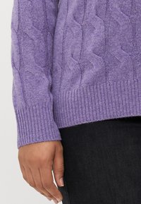 Lila Kabelstrickpullover mit geripptem Saum und Bündchen, aus weichem Stoff gefertigt, mit einem strukturierten Zickzackmuster verziert.