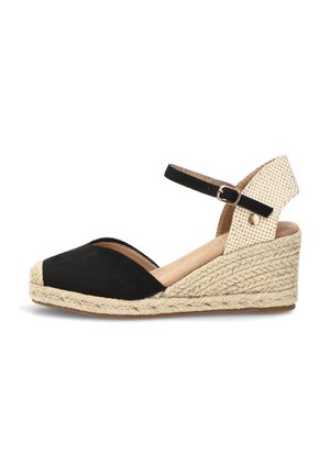 Sandalia de cuña negra y beige con suela de esparto tejida, punta cerrada y correa ajustable en el tobillo con hebilla.