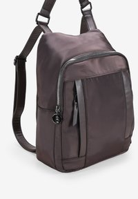 Zaino in nylon marrone con una texture liscia, tasca frontale con zip, dettagli in pelle e tracolla regolabile. Forma compatta e rettangolare.