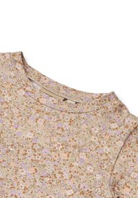 Bluza s cvjetnim uzorkom i okruglim izrezom. Ima male ljubičaste, ružičaste i smeđe cvjetove na bež pozadini. Meki, teksturirani materijal.