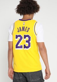 Maglia dei Lakers in giallo con accenti viola, con "JAMES" e il numero "23" in carattere grande sul retro, realizzata in tessuto traspirante.