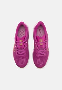 Roze sport schoenen met een mesh bovenwerk, vetersluiting, gouden accenten en een gemar cheerde zool. Lichtgewicht ontwerp geschikt voor actieve gebruik.