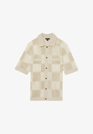 Bežina košulja kratkih rukava, pletena s kariranim uzorkom mrežaste tkanine. Ima ovratnik, dva prednja džepa i smeđe gumbe. Mekana tekstura.