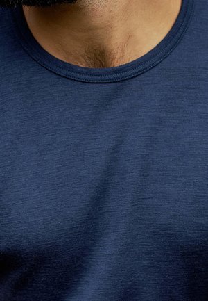 Marineblå bomulds T-shirt med rund hals, der har en blød, tekstureret overflade. Har en afrundet halsudskæring og synlige sting rundt om kraven.
