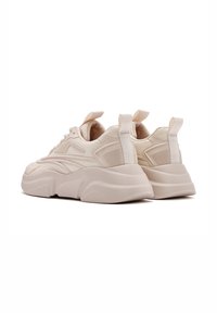 Beige Chunky Sneakers mit strukturiertem Mesh-Obermaterial, dicker Gummisohle und dekorativen Akzenten. Mit einer Zuglasche an der Ferse für einfaches Anziehen.